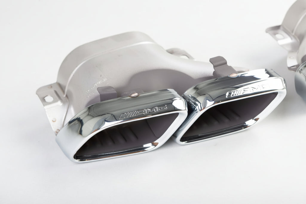 Chrome car exhaust pipes on a white background with 'Mercedes-Benz' branding.